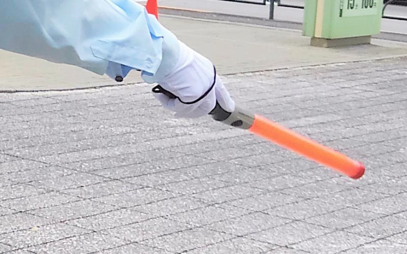 誘導灯を持つ警備員